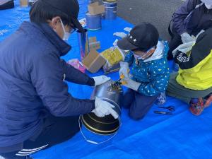 ロケットストーブを組み立てる参加者