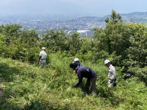 大音寺山から見る浅間温泉地区と草刈りをする参加者