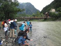 河童橋近くで梓川の水に触れる参加者