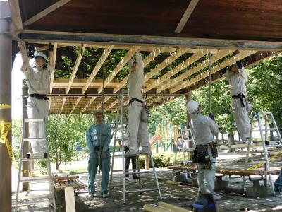 協力して新しい藤棚を設置する様子